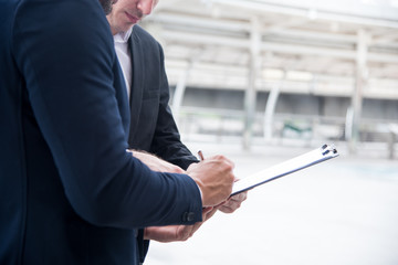 Businessman checked and sign a inspection documents. Businessman analysis maketing plan, He had a profressional of  business maketing.