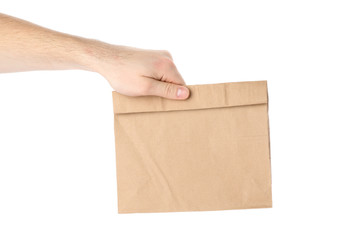 Male hand holds paper bag, isolated on white background