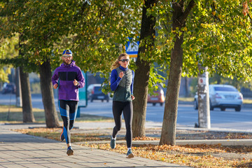 Fototapeta premium Young couple run on the street in the morning