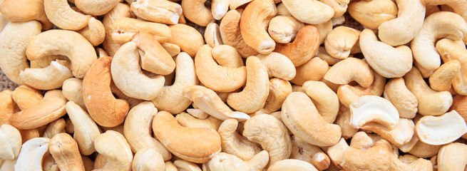 Cashew nuts peeled full background, closeup view, banner