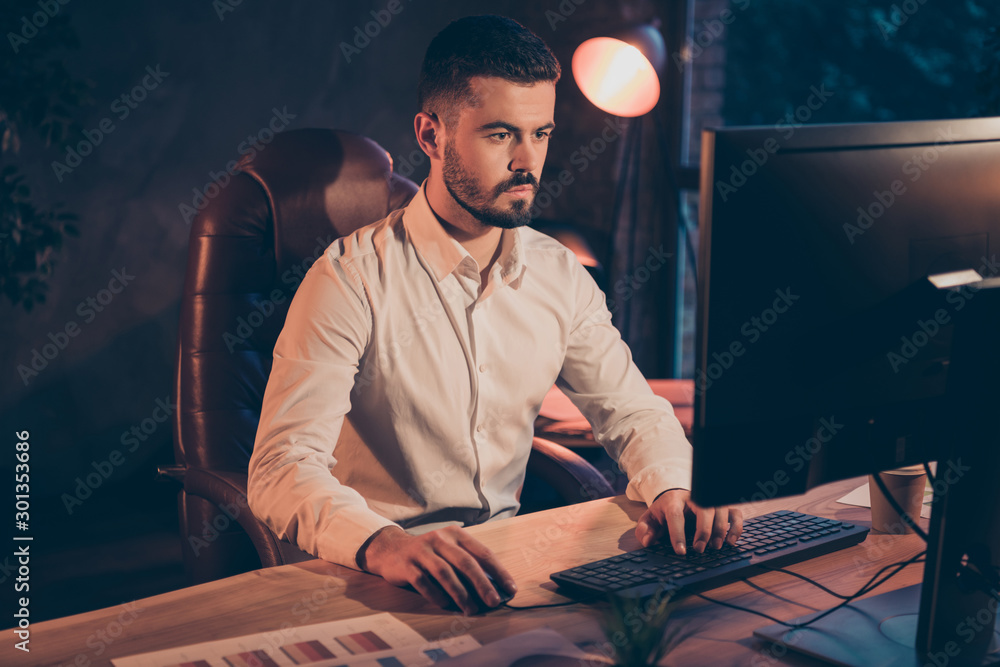 Poster photo of serious confident clever businessman working at night shift developing his project eliminat
