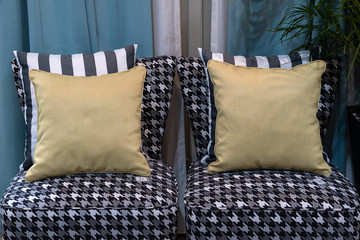 Modern yellow fabric pillow with black and white stripes pattern on the casual clothes checkered chair interior furniture decoration concept