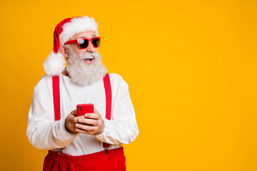 Fototapeta na wymiar Profile side photo of crazy funky grey hair hipster grandfather in santa claus hat use cellphone find tradition x-mas eve shopping discounts look copyspace isolated bright color background