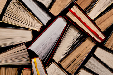 Naklejka premium Books. Lots of colourful thick open books stand on a dark background
