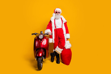 Full size photo of confident grandfather in red santa claus hat true driver rider hold big sack...