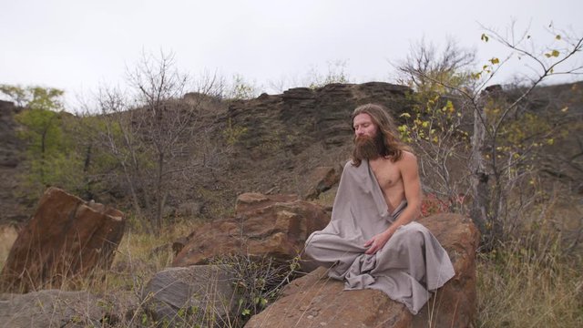 Yogi sitting on the rock in meditation