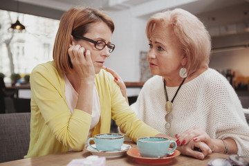 Senior woman comforting her upset adult daughter. Depressed mature woman meeting her elderly mother