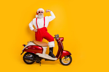 Full body photo of santa ambitious man stand near moped show strength biceps delivered heavy gifts...