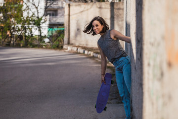 Fototapeta na wymiar Young woman with blue penny skateboard in casual wearing