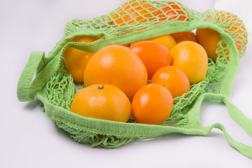 Green string bag with oranges closeup. Ecology. Environmental Protection. ecological package.