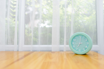 Light green alarm clock Placed on the table in the bedroom