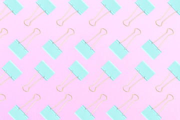 Turquoise and baby pink colors. Pattern made of turquoise clips for papers on a pink background. Flat lay style. Background for business and education.