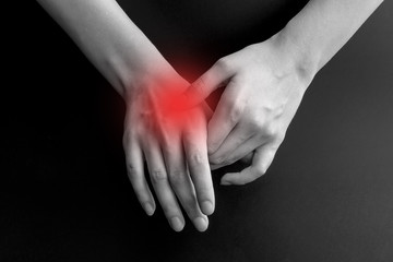 Pain in a wrist. holding hand to spot of wrist pain
