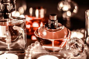 Perfume bottle and vintage fragrance on glamour vanity table at night, pearls jewellery and eau de...
