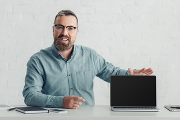 handsome businessman in shirt holding laptop with copy space