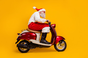 Full length low angle view photo of santa white hair grandpa rushing x-mas party by moped wear sun...