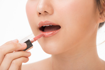 Obraz premium Young beautiful woman professional beauty vlogger or blogger applying lipstick cream to her mouth, doing a make up tutorial