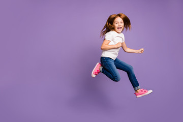 Fototapeta na wymiar Full body profile photo of funny small foxy lady jumping high rejoicing cheerful mood rushing shopping discounts wear casual white t-shirt jeans isolated purple background