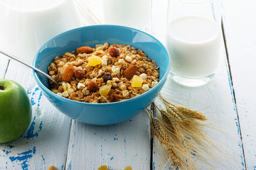 Health food. Muesli with milk and the baked apple on old wooden background. High key. Close up. Selective focus.