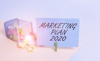 Writing note showing Marketing Plan 2020. Business concept for schedule defining brand selling way in next year Trash bin crumpled paper clothespin reminder office supplies