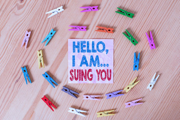Conceptual hand writing showing Hello I Am Suing You. Concept meaning create a case to accuse someone from his actions Colored crumpled papers wooden floor background clothespin