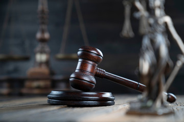 Justice concept. Themis statue and judge's gavel on the dark background.