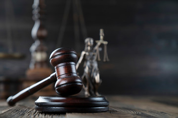 Justice concept. Themis statue and judge's gavel on the dark background.