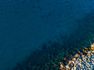 Aerial view of a seabed with rocks emerging from the sea, seabed seen from above, transparent water