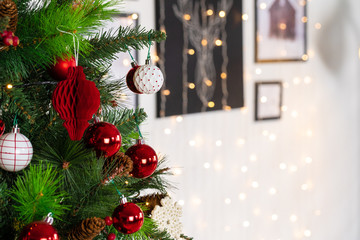 Red and white baubles hanging from a Christmas tree close up