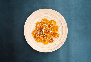 Dry orange slices. Top view of citrus slices on wooden plate. Healthy and organic fruits. Flat lay.