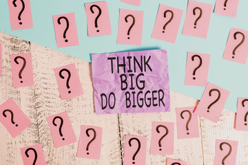 Text sign showing Think Big Do Bigger. Business photo showcasing Raise the Bar and Aim far Higher than the Usual Scribbled and crumbling papers with thick cardboard above wooden table