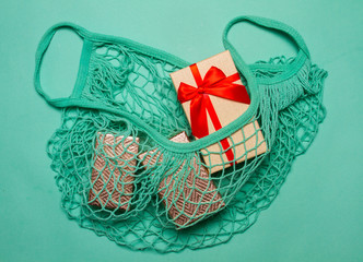 Trm gift boxes in a string bag on neo mint paper background.