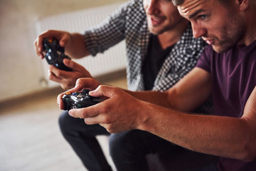 Group of friends have fun playing console game indoors at living room