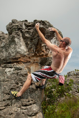 A rock climber ascending a bolder in Mpumalanga, South Africa.
