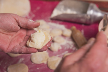 Cooking in the kitchen of the Ukrainian national dish using white flour dough and cottage cheese stuffing and boiled potatoes. Vareniks.