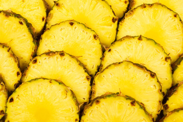 Pineapple juicy yellow slices background. Top view.