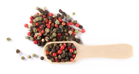 Colorful pepper pile in wooden spoon isolated on white background, top view