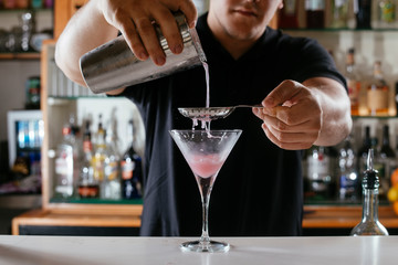 Professional barman making cosmopolitan cocktail. - obrazy, fototapety, plakaty