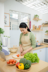 Young Asian woman at kitchen cooking breakfast