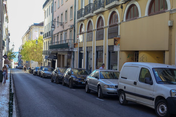 Lisbon, Lisbon, November 17, 2019: The beautiful architectures in a shopping street in the historic city center. Portuguese mosaic stone sidewalks, sconces in buildings, iron balconies