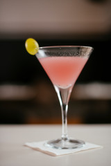 Cosmopolitan cocktail served on bar counter