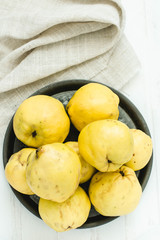 Fresh quince fruits on white wooden table