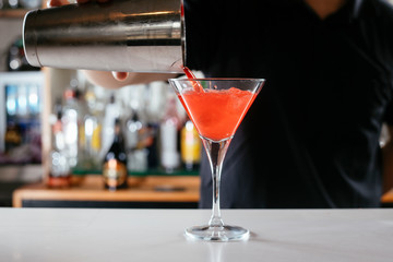 Barman making red cocktail. Professional bartender preparing Manhattan cocktail. 