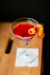 Red Cosmopolitan cocktail served on bar counter.