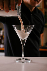 Close up of bartender making martini. Cocktail based on milk and coffee.
