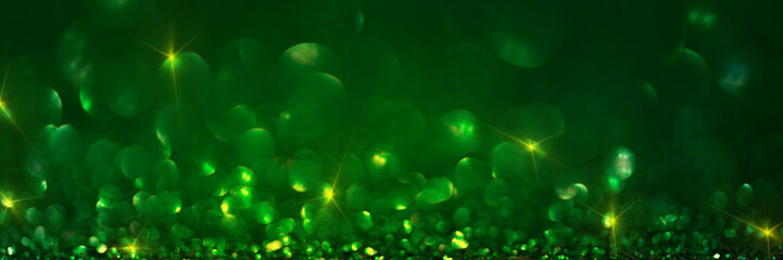 Banner 3:1. Abstract glitter lights on green background. Christmas greeting card. Christmas or New Year celebration concept. Copy space. Soft focus