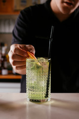 Professional barman making green cocktail