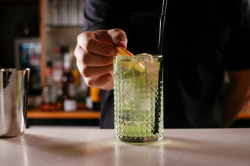 Professional barman making green cocktail