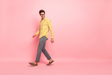 Full size profile photo of handsome business guy going down street finished working week wear specs stylish striped shirt pants isolated pink color background