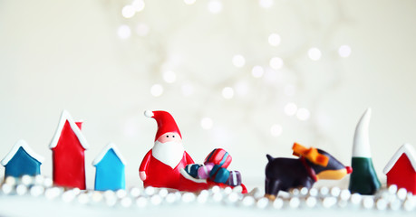 Christmas card with Santa Claus and gifts. White bokeh background with festive Christmas decorated and have copy space.